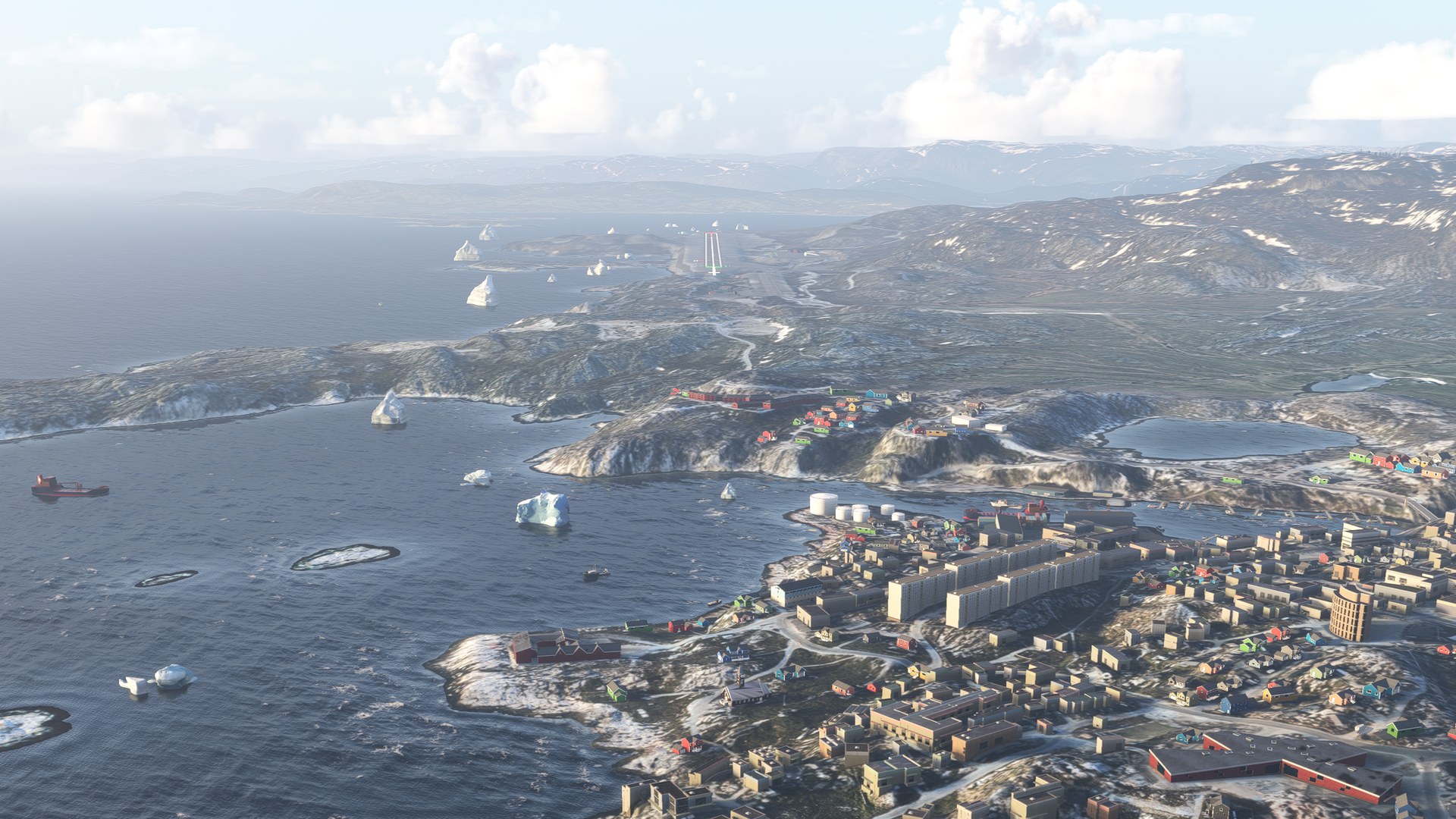 An aerial view of Ilulissat's colourful town and rocky coastline, with icebergs in the bay, in Microsoft Flight Simulator 2024