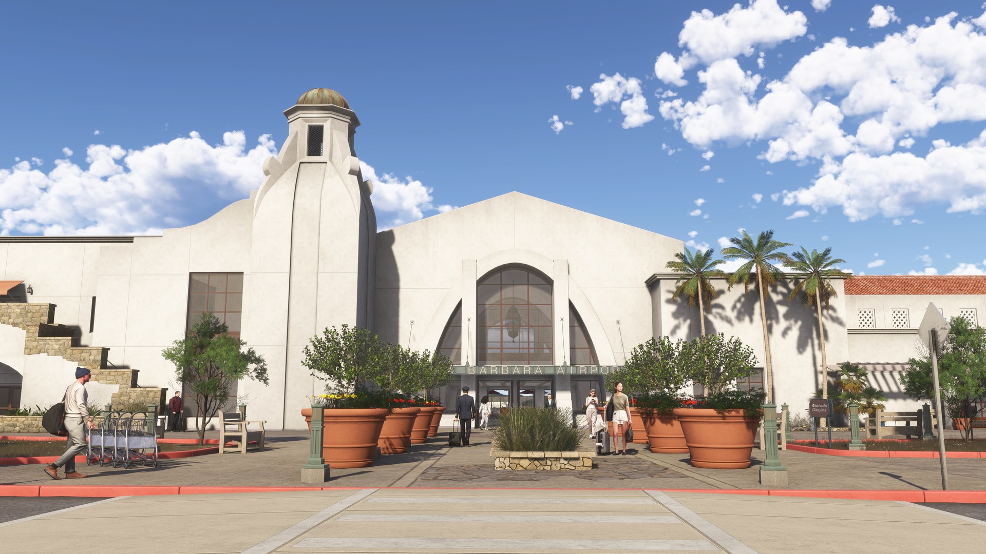 The white Spanish-style entrance of Santa Barbara Airport's terminal, with a tall arched window, palm trees and planters, in Microsoft Flight Simulator 2024