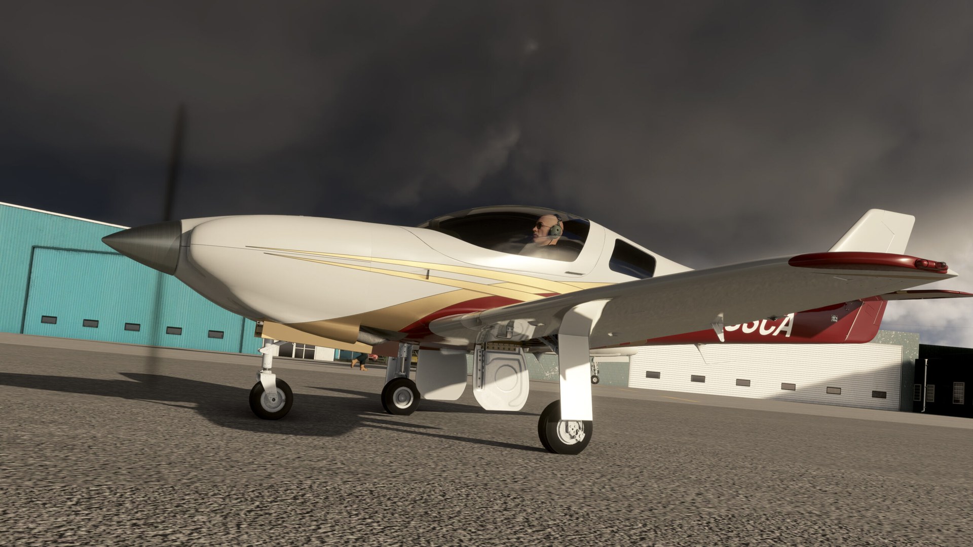 A white Legacy RG550 with red and gold stripes on the apron, pilot in the cockpit